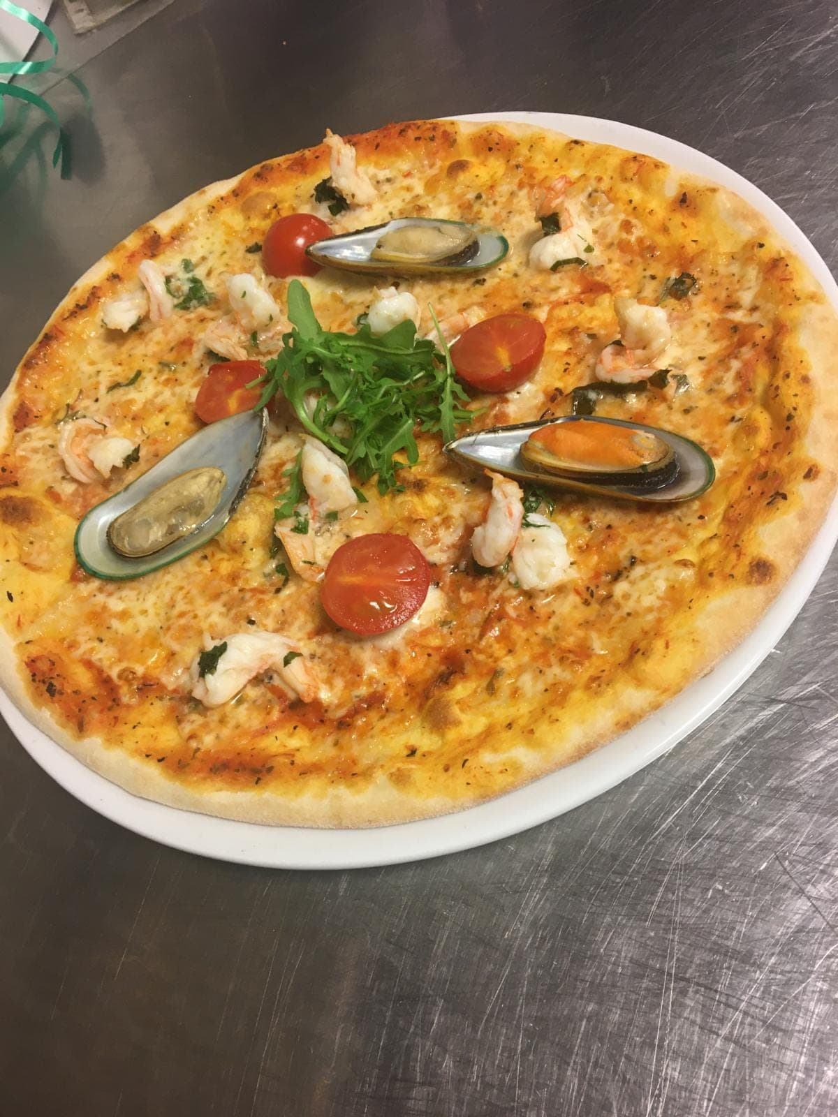 Nygräddad pizza med räkor, musslor, körsbärstomater och ruccola